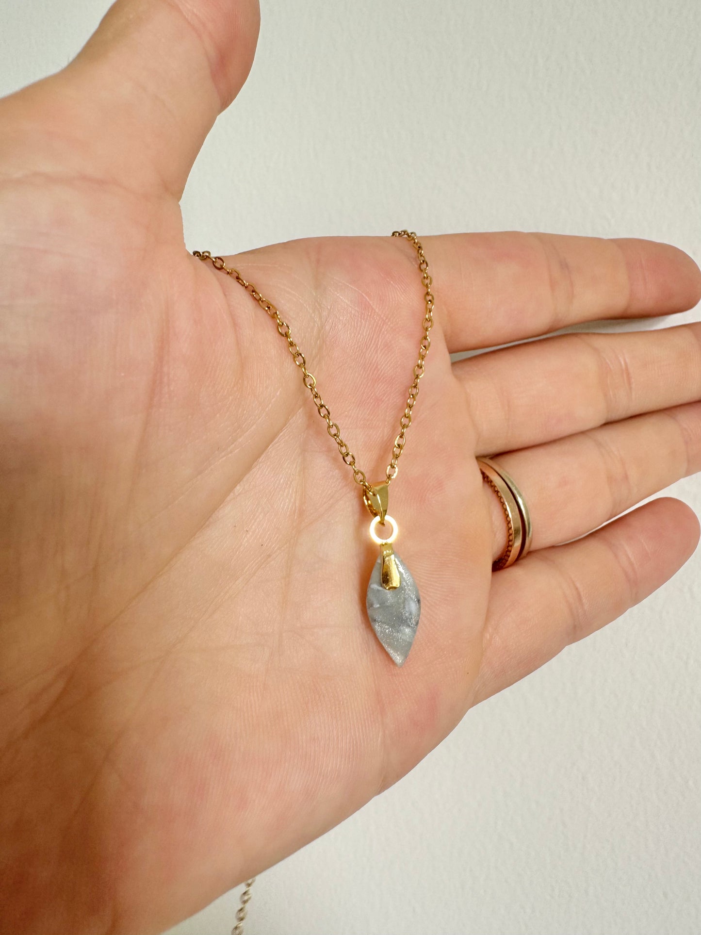 golden necklace with small petal pendant in crystal blue marbled